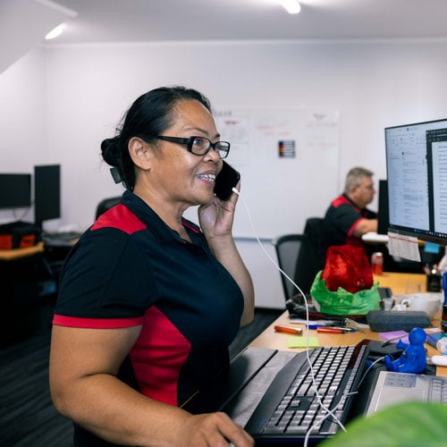 lady in office on computer answering a call on phone